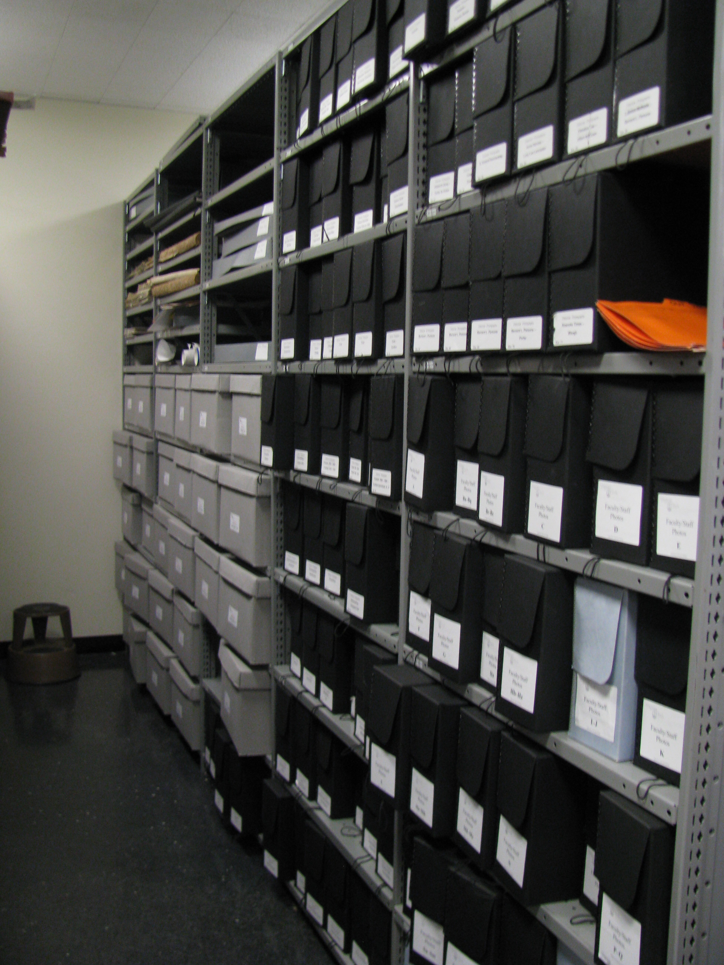 Our historical photograph collection is in black acid-free boxes and is organized generally by topic. Beyond it, you can see some bound and boxed newspapers above and part of our collection of vertical files on university history.