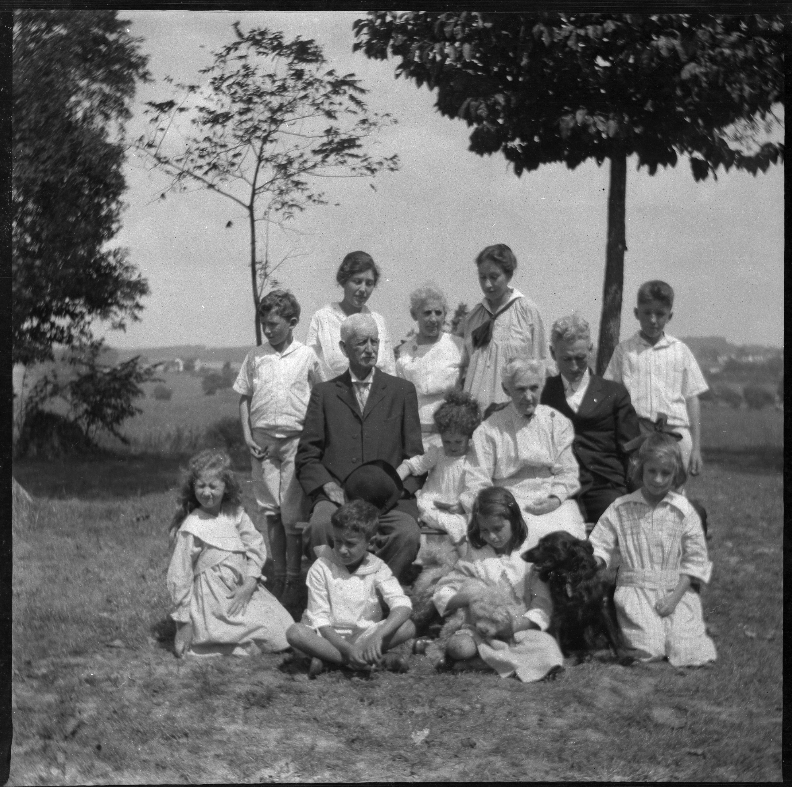 Family outside with trees and campus/town in distance.