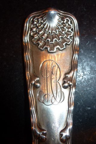 close-up of spoon handle with monogram and decoratin