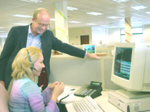 Rick Boucher speaks with woman at computer.