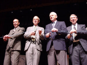 Four men at a ribbon cutting event.